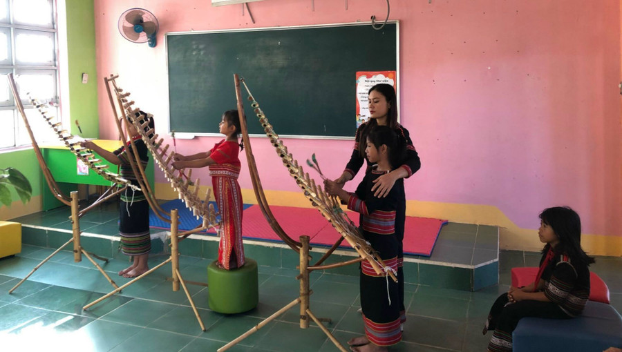 Cô Htoanh tận tình chỉ bảo cho học sinh đánh đàn T’rưng. Ảnh: Dung Nguyễn