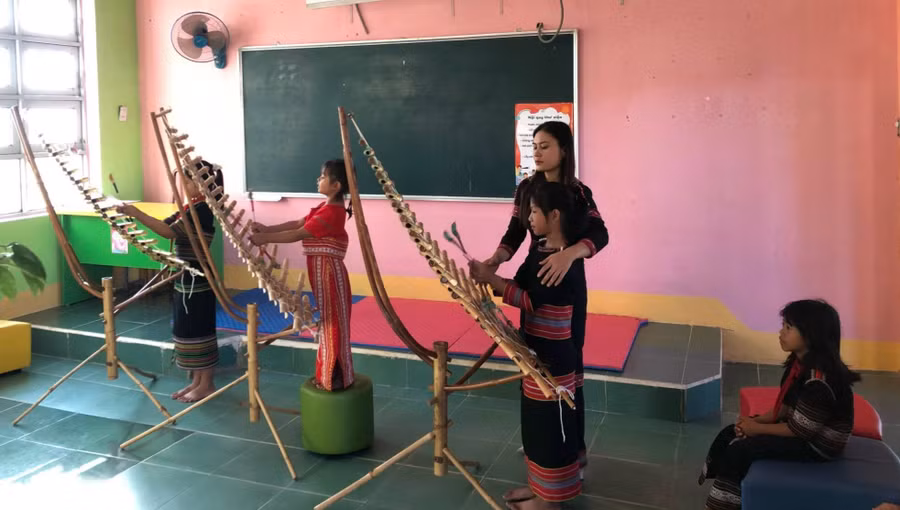 Cô Htoanh tận tình chỉ bảo cho học sinh đánh đàn T’rưng. Ảnh: Dung Nguyễn