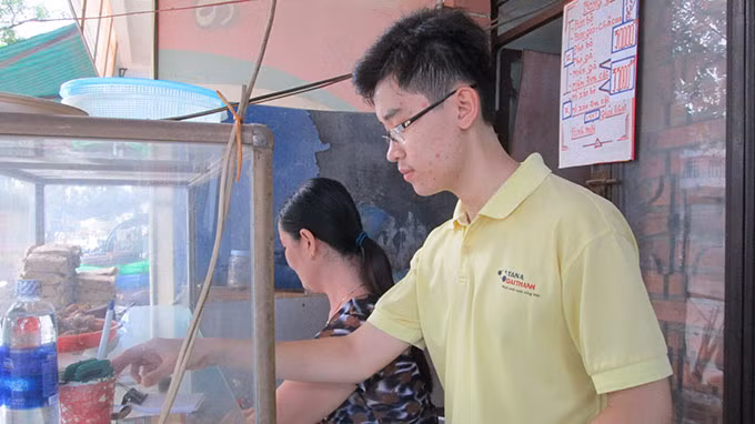 Phan Công Thành phụ nấu với mẹ. Ảnh: Lam Giang