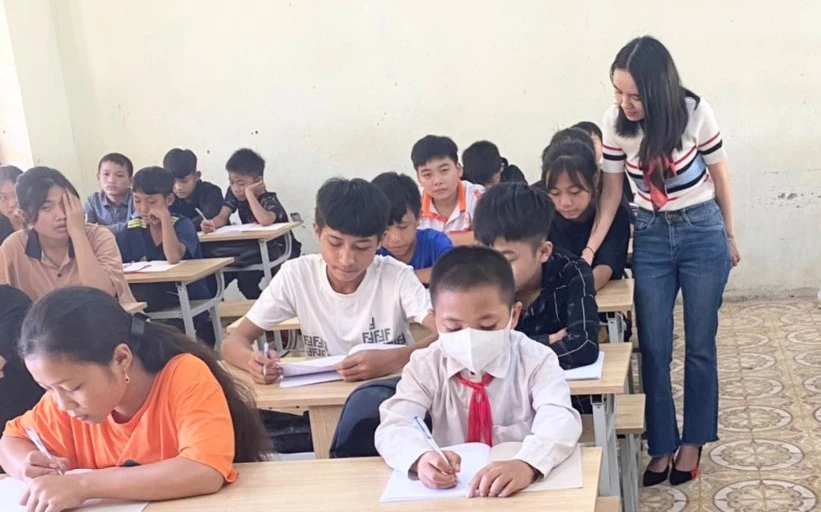 Giáo viên quan tâm, tạo hứng thú học tập trên lớp là biện pháp hiệu quả giúp học sinh hào hứng đến trường. Ảnh: Cô Vi Thị Ỏn và học sinh trong lớp học.