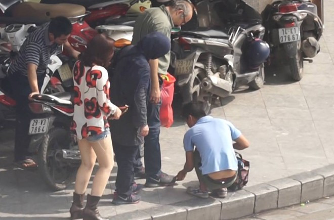Khách nước ngoài bị đội quân đánh giày chặn lại giữa đường. Ảnh: Phan Anh. Công an Hà Nội triệu tập ‘nhóm đánh giày trấn lột’