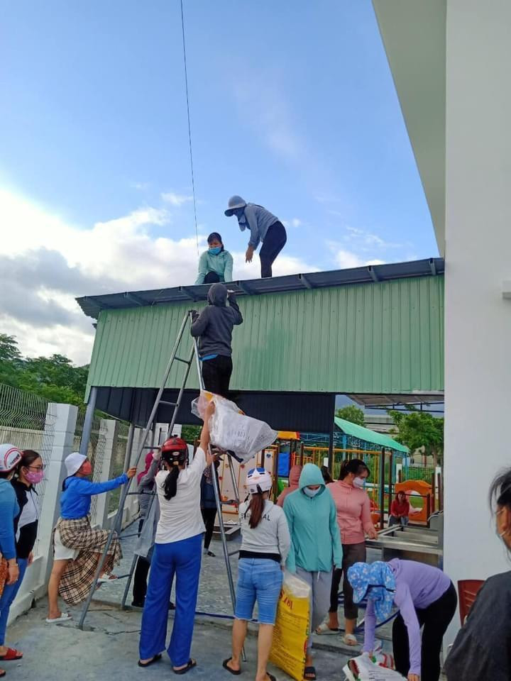 Các giáo viên mầm non một số trường học ven biển quận Liên Chiểu chuyển bao cát để chằng chống mái tôn.