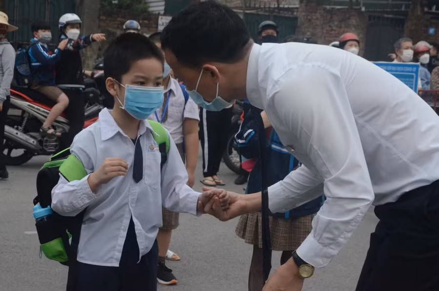 Thầy giáo Trường Tiểu học Đoàn Kết (quận Long Biên, TP Hà Nội) đón học sinh lớp 1 vào học. Ảnh: Ngô Chuyên.