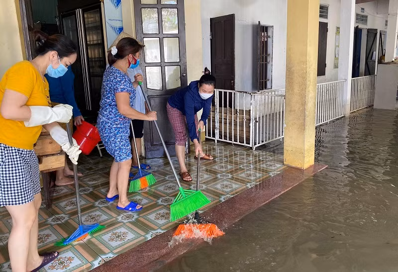 Giáo viên huyện Quỳnh Lưu dọn dẹp vệ sinh trường lớp khi nước bắt đầu rút.