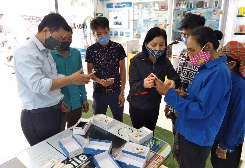 Thầy Nguyễn Đức Nguyện (ngoài cùng bên trái) vận động và bảo lãnh cho phụ huynh mua máy tính trả góp. Ảnh: NTCC