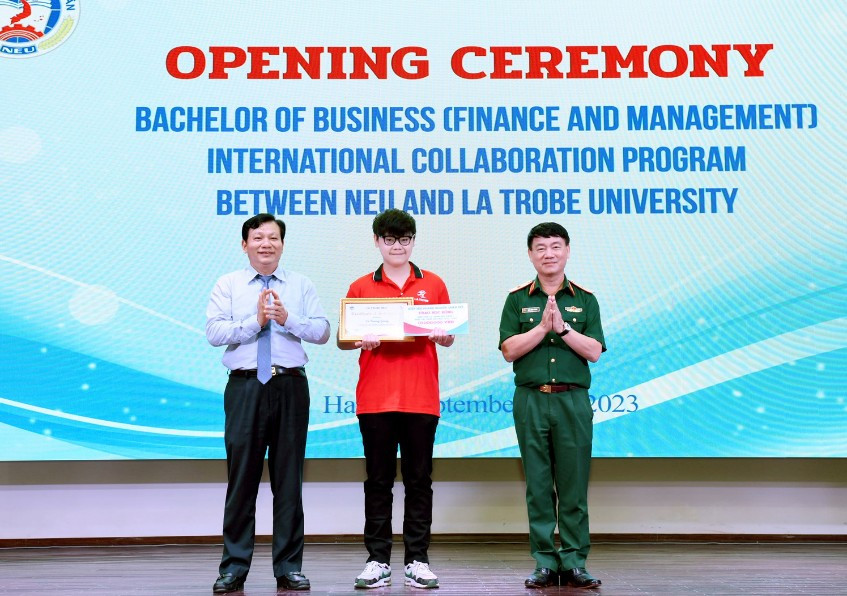 Thiếu tướng Trần Đình Thăng - Cục trưởng Cục kinh tế Bộ Quốc phòng, Chủ tịch Hiệp hội doanh nghiệp Quân đội và PGS.TS Hoàng Xuân Quế - Viện trưởng Viện Ngân hàng - Tài chính, Trường ĐH Kinh tế quốc dân trao học bổng cho sinh viên Võ Trường Giang.