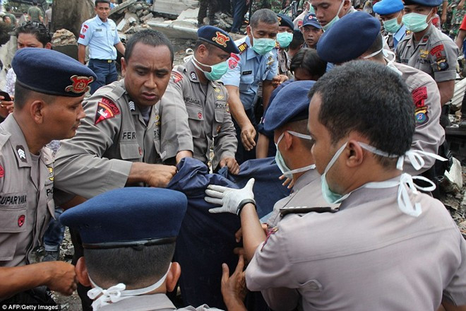 Cảnh sát và binh sĩ quân đội đưa một thi thể nạn nhân rời khỏi hiện trường. Ảnh: AFP