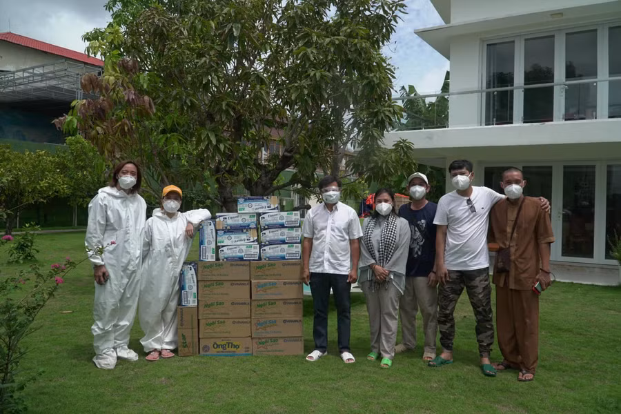 Vợ chồng Việt Hương (mặc đồ bảo hộ màu trắng) chụp ảnh cùng ông Đoàn Ngọc Hải.