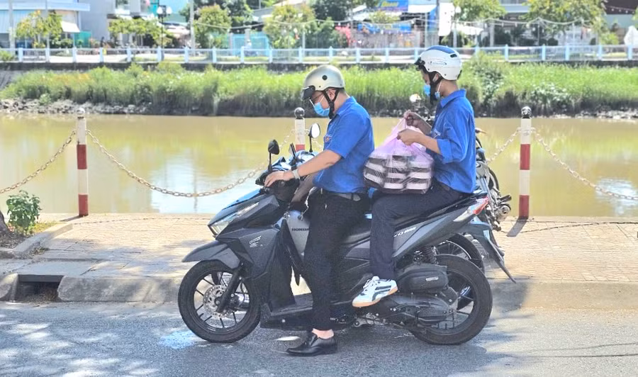 Nhóm thanh niên tình nguyện vận chuyển những phần cơm trưa miễn phí đến điểm thi tặng cho thí sinh.