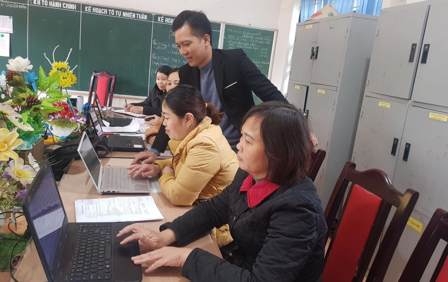 Thầy Lê Ngọc Anh (đứng), Hiệu trưởng Trường PTDTBT THCS Tà Chải hỗ trợ giáo viên kỹ năng chuyển đổi số. Ảnh: NTCC