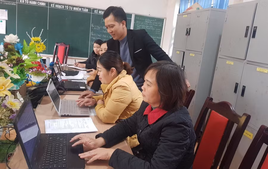 Thầy Lê Ngọc Anh (đứng), Hiệu trưởng Trường PTDTBT THCS Tà Chải hỗ trợ giáo viên kỹ năng chuyển đổi số. Ảnh: NTCC Thầy Lê Ngọc Anh (đứng), Hiệu trưởng Trường PTDTBT THCS Tà Chải hỗ trợ giáo viên kỹ năng chuyển đổi số. Ảnh: NTCC