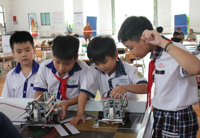 Các em HS tiểu học cùng nhau sáng tạo robot trong giờ học thực hành. Ảnh: T.G