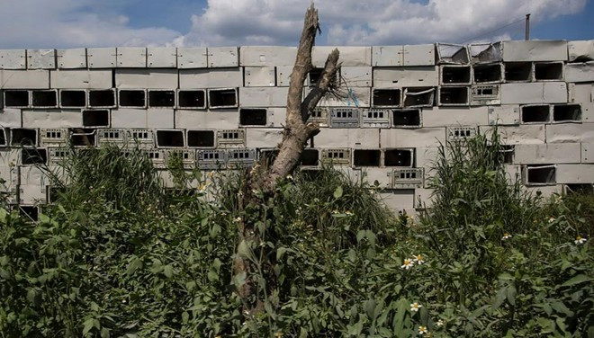 Vỏ thùng kim loại chất chồng trong thị trấn. 1