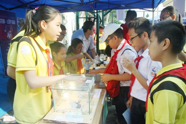 Học sinh say sưa giới thiệu mô hình hiệu ứng nhà kính. Mô hình được chế tạo dựa trên nguyên lý nhà kính và số liệu quan trắc qua nhiệt kế điện tử. Thông qua mô hình này, học sinh có thể hiểu rõ hơn về sự nóng lên toàn cầu, từ đó có ý thức bảo vệ môi trường tốt hơn.