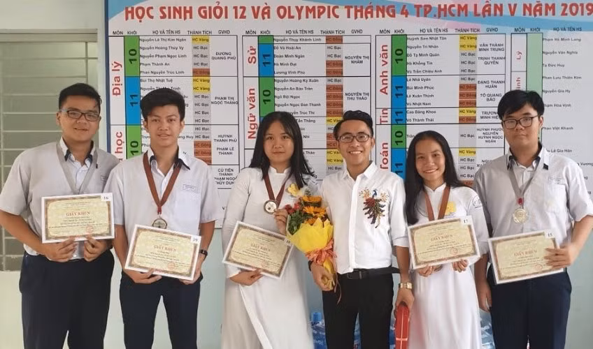 Thầy giáo Phạm Lê Thanh (người cầm hoa, đứng giữa) và các em học sinh giỏi môn Hoá học. Ảnh: NVCC