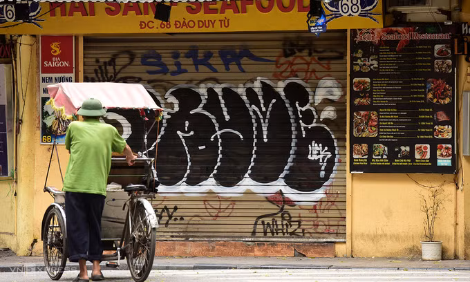 Lái xe xích lô giữa quán xá đóng cửa vì đợt cách ly toàn xã hội. Ảnh: Giang Huy.