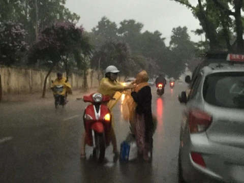 Cô gái dừng xe mặc áo mưa cho cụ bà: "Việc làm này hết sức bình thường"