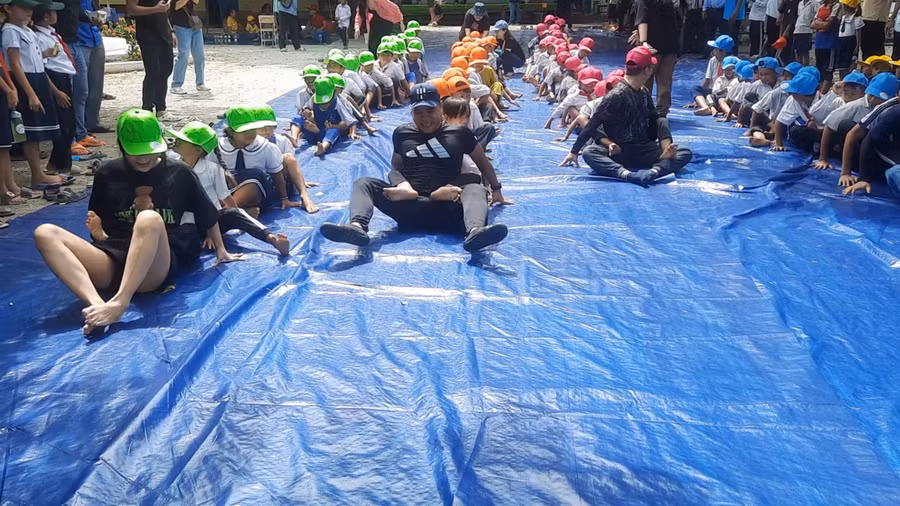 Thiếu nhi tham gia trò chơi Đua ghe Ngo trên cạn.