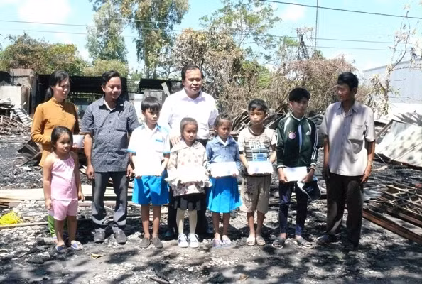 Ông Nguyễn Minh Luân - GĐ Sở GD&ĐT Cà Mau trao số tiền hỗ trợ của Bộ trưởng Phùng Xuân Nhạ đến gia đình GV và gia đình các em HS