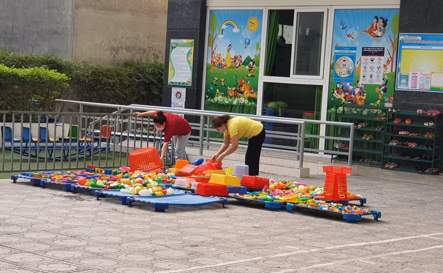 Nhân viên Trường Mầm non Ngôi Sao Sáng vệ sinh đồ chơi cho trẻ. Ảnh: Hồ Phúc
