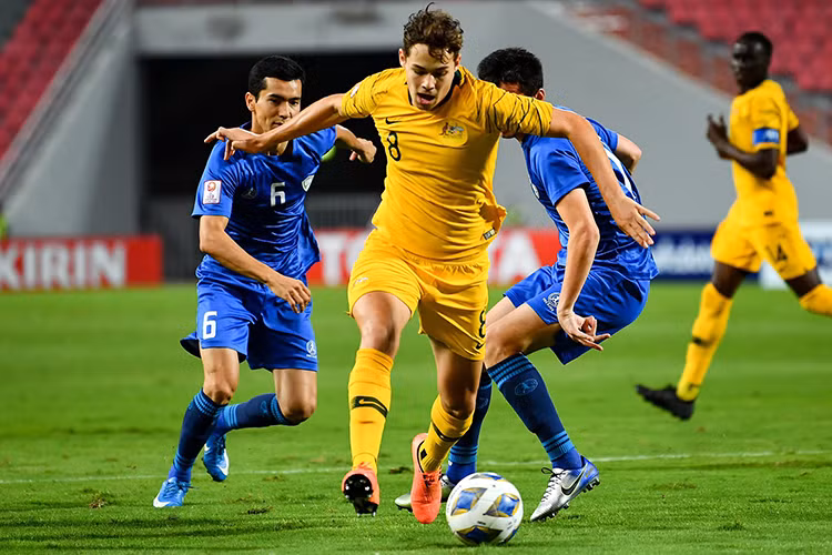 Australia (áo vàng) trở lại đấu trường Olympic sau 12 năm vắng bóng. Ảnh: AFC.