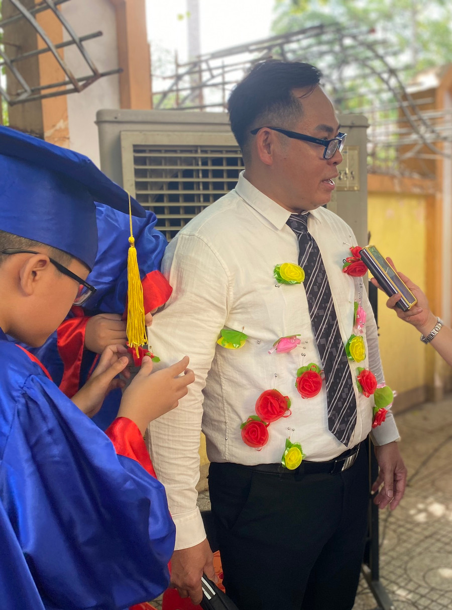 Không chỉ các em cài hoa lên áo cha mẹ mà áo các thầy cô cũng rất nhiều hoa. Ấn tượng với thầy giáo đã 33 chuyến đò, học sinh lớp 5 bốn thay nhau đến cài hoa lên áo thầy Đỗ Xuân Trường – Chủ nhiệm lớp 5 bốn.