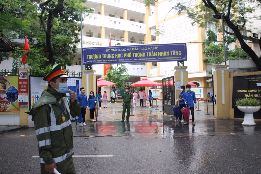 Điểm thi luôn có thanh niên tình nguyện hỗ trợ thí sinh. Các tình nguyện viên tại điểm thi Trường THPT Trần Nhân Tông chuẩn bị sẵn ô để che mưa cho thí sinh vào phòng thi.