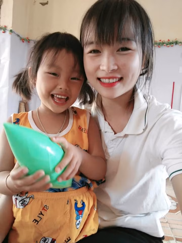 Cô giáo Lò Thị Thương rạng rỡ bên học trò của mình.