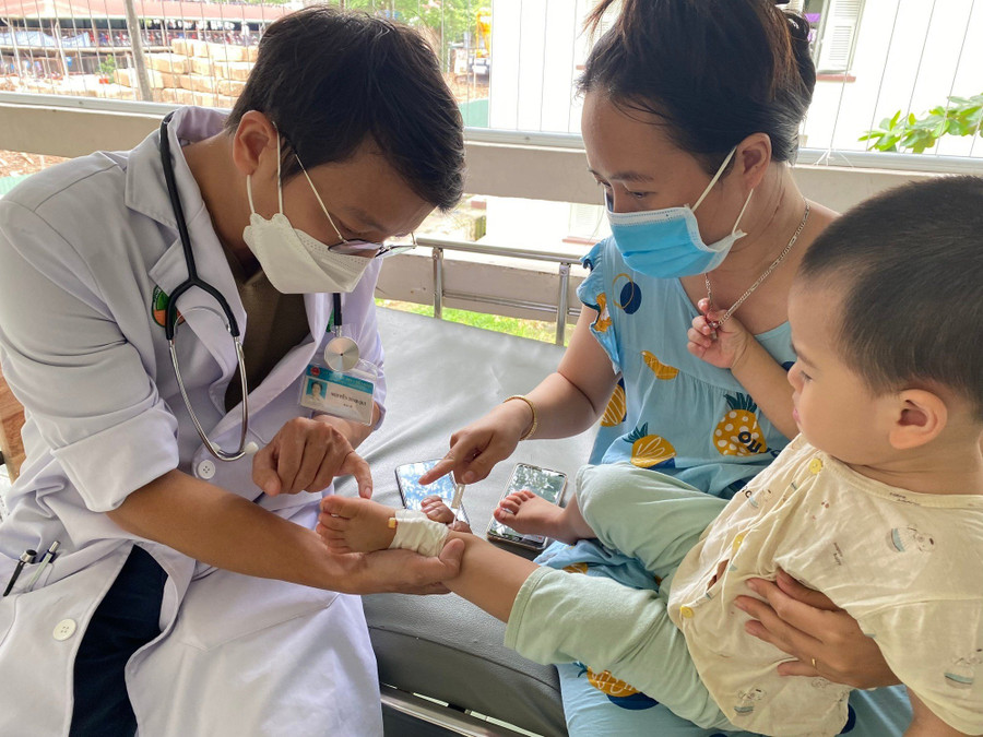 ThS.BS Nguyễn Đình Qui đang khám cho bệnh nhi.