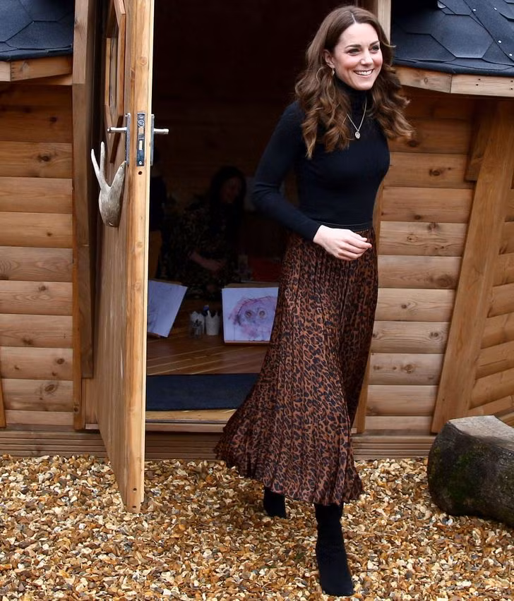 Kate Middleton mặc một chân váy da báo trị giá $12 của Zara và kết hợp với một chiếc áo cổ lọ màu đen.