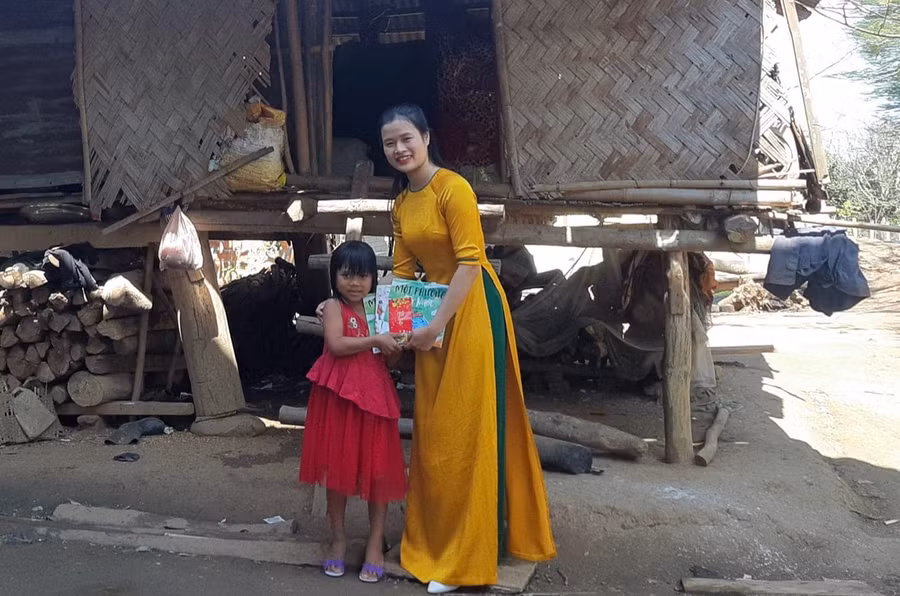 Giáo viên Trường Tiểu học – THCS A Xing lì xì sách cho học sinh trong Tết Nguyên đán. Ảnh: Mai Trọng