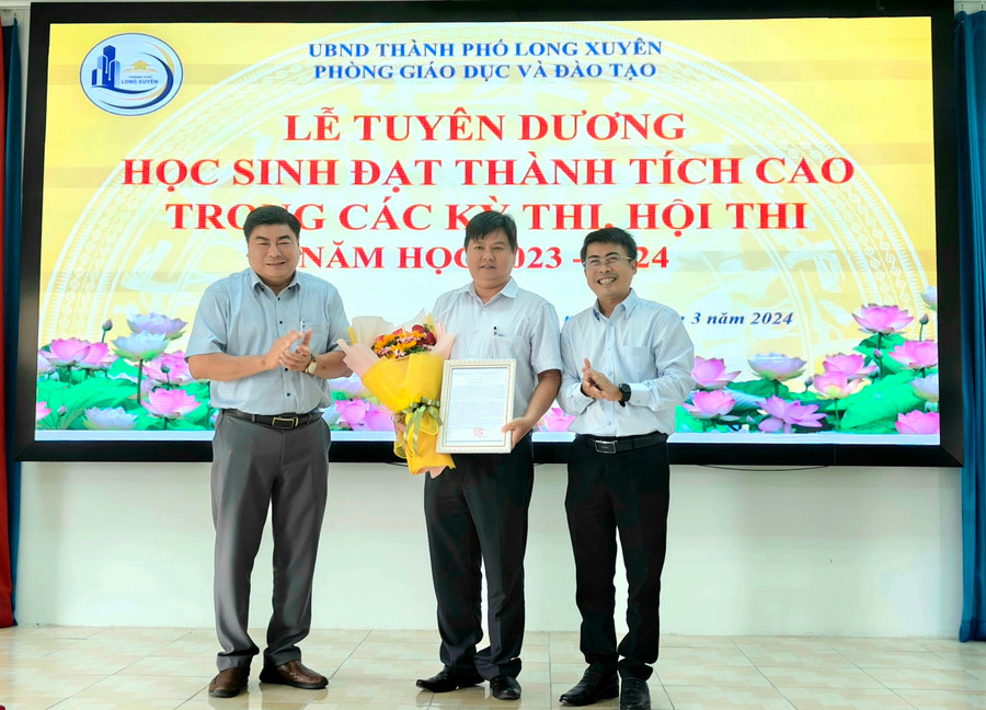 Ông Nguyễn Bảo Sinh - Phó Chủ tịch UBND TP Long Xuyên và ông Dương Kiếm Anh - Trưởng phòng GDĐT trao hoa, Giấy cảm tạ nhà tài trợ.