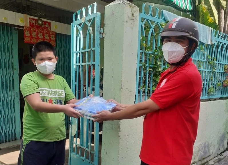 Giáo viên tại Quận 8, TPHCM mang sách đến nhà cho học sinh.