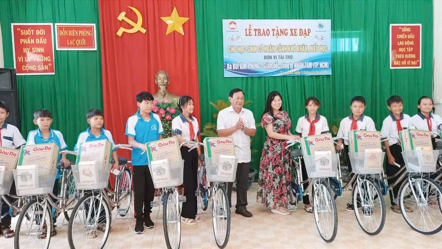 Ông Nguyễn Tiếc Hùng - Chủ tịch Ủy ban MTTQ Việt Nam tỉnh An Giang và nhà tài trợ trao xe đạp và quà cho học sinh.