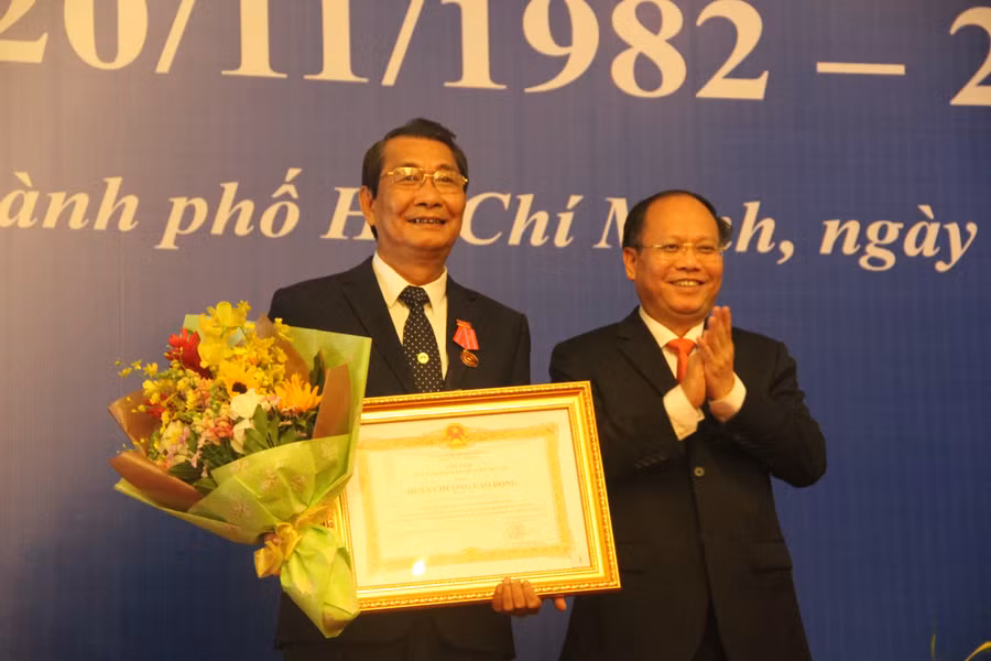 Đồng chí Tất Thành Cang, Phó Bí thư Thường trực Thành ủy TP.HCM trao Huân chương Lao động hạng Ba cho ông Nguyễn Hữu Hùng, Chủ tịch Công đoàn Giáo dục TP