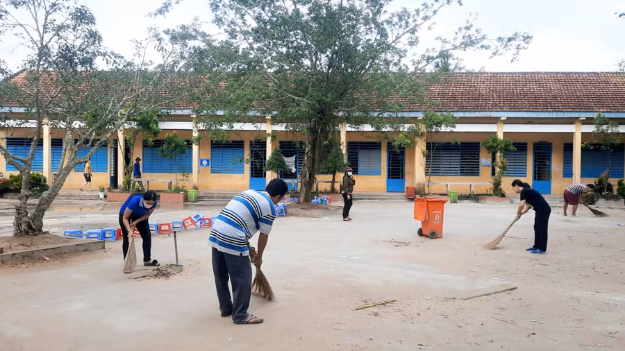 Cán bộ, giáo viên làm vệ sinh khuôn viên trường lớp chuẩn bị khai giảng năm học mới.
