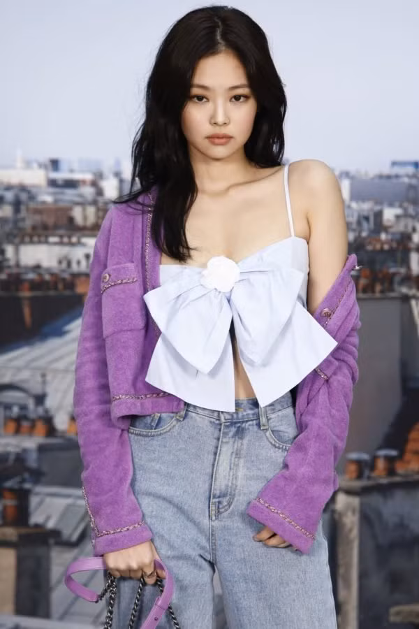 Jennie Black Pink đã lăng xê dáng trang phục này với mẫu áo hai dây cúp ngực, đính nơ to bản cùng màu sắc áo khoác tím là điểm nhấn của bộ trang phục.
