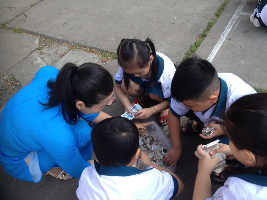 Cô, trò Trường TH Trần Đại Nghĩa (Vĩnh Long) kiểm số tiền đập heo đất chuẩn bị quà Tết cho HS nghèo.