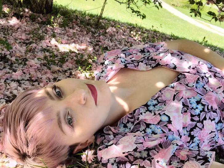 Chiếc váy hoa của cô gái gần giống với những bông hoa bên cạnh. Và khi nằm xuống dưới đất, bộ trang phục khiến cô như hoà mình vào cùng những bông hoa.