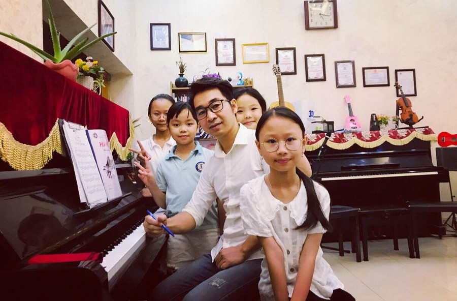 Nhạc sĩ Lê Dũng và các em học sinh.