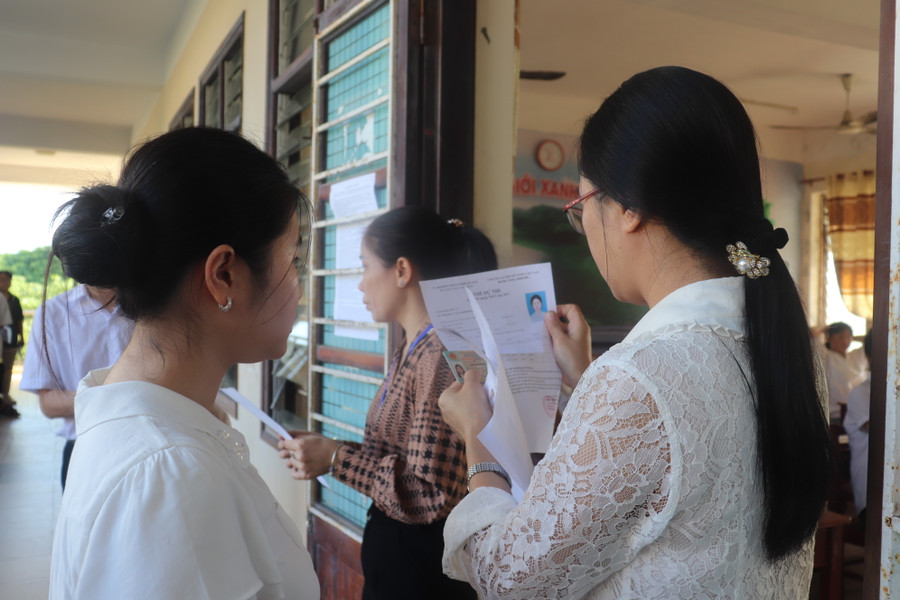 Cán bộ coi thi tại điểm thi Trường THPT Trần Phú đối chiếu thông tin của thí sinh khi gọi thí sinh vào phòng thi.