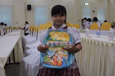 Ngọc Mai vui mừng khi nhận học bổng và đồ dùng học tập từ nhà hảo tâm trước năm học mới.