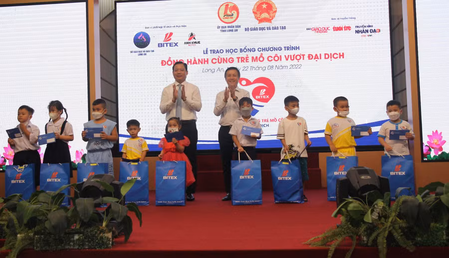 Ông Phạm Tấn Hoà, Phó Chủ tịch UBND tỉnh Long An và ông Nguyễn Xuân Dũng, Chủ tịch Hội đồng quản trị Tập đoàn BITEX GROUP tặng học bổng cho học sinh mồ côi cha, mẹ vì dịch bệnh Covid-19.