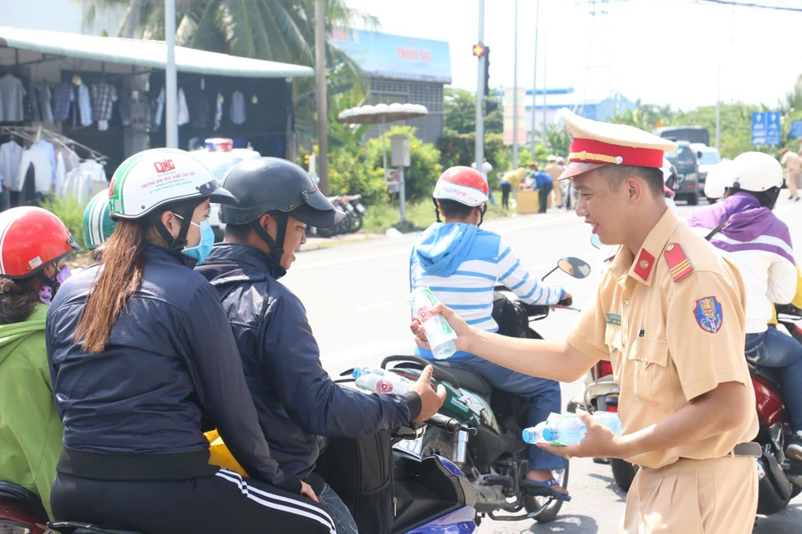 Cảnh sát giao thông phát nước suối, khăn lạnh miễn phí cho người dân về quê vui lễ