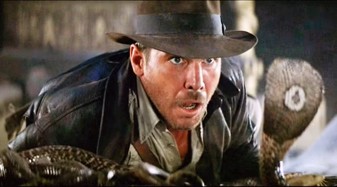 9. Raiders of the Lost Ark (1981) - 389 triệu USD: Ban đầu, câu chuyện về Chiếc rương Thánh tích được nhắm cho Philip Kaufman, nhưng rốt cuộc nhà sản xuất George Lucas giao dự án cho Steven Spielberg. Ông từng lo lắng rằng Harrison Ford đã bị “chết vai” Han Solo từ loạt Star Wars và kinh phí thực hiện bộ phim có thể lên tới 20 triệu USD. Cuối cùng, nhờ được Lucas thuyết phục cùng sự mạo hiểm của hãng Universal, nhân vật huyền thoại Indiana Jones đã ra đời và chinh phục nhiều thế hệ khán giả suốt gần bốn thập kỷ qua. 10 bom tấn ăn khách nhất của đạo diễn Steven Spielberg