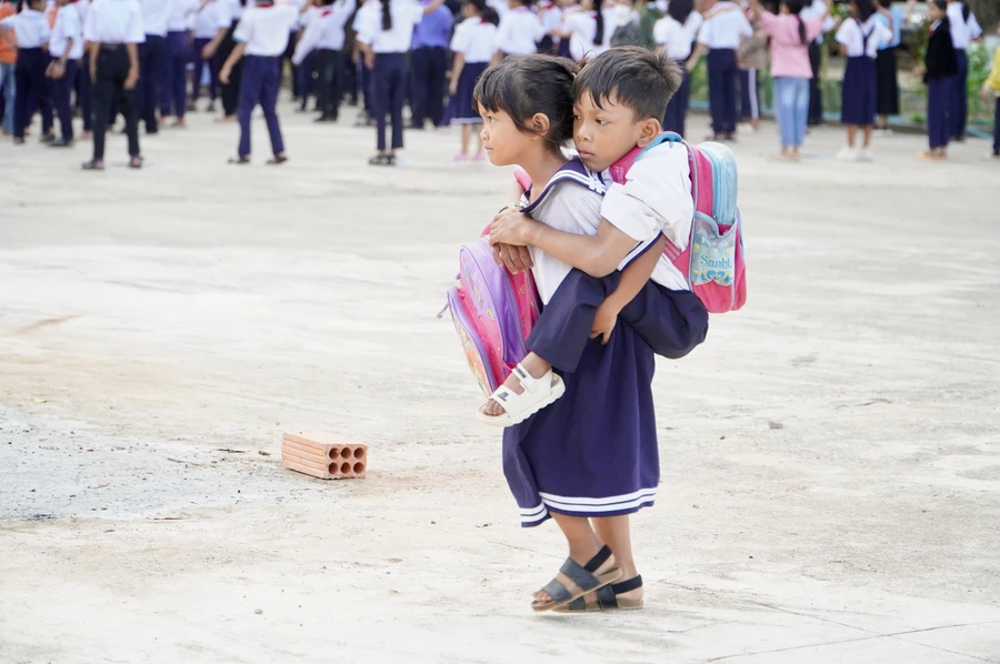 Mấy tháng qua, Y Juyên trở thành đôi chân giúp A Đinh đến trường. Ảnh: Dung Nguyễn