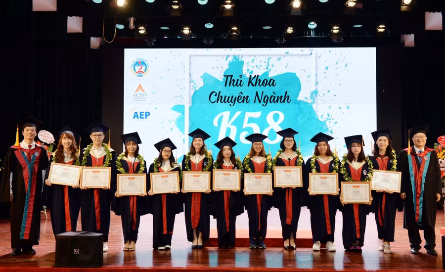 PGS.TS Phạm Hồng Chương và TS. Vũ Văn Ngọc tặng hoa và giấy khen cho các sinh viên thủ khoa các chuyên ngành.