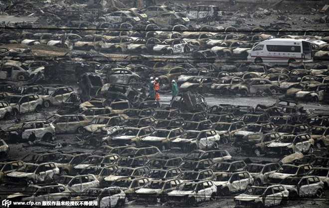 Khoảng 1.000 xe mới cháy rụi do đỗ gần nhà kho. Ảnh: cfp.cn Cảnh tìm người mất tích tại hiện trường vụ nổ ở Thiên Tân