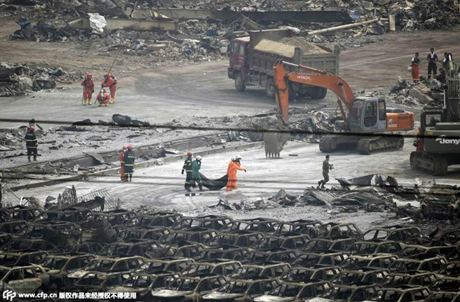 Các thiết bị cơ giới hạng nặng dọn dẹp hiện trường. Hàng chục người mất tích sau nỗ lực kiểm soát ngọn lửa từ vụ nổ đầu tiên. Ảnh: cfp.cn Cảnh tìm người mất tích tại hiện trường vụ nổ ở Thiên Tân