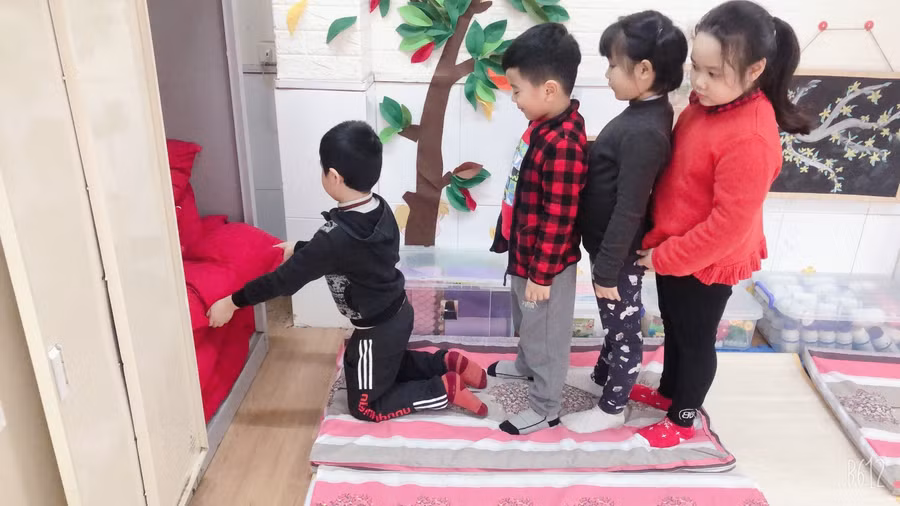 Các bé lớp mẫu giáo lớn Trường Mầm non Hoa Sen (Hà Đông – Hà Nội) xếp hàng lấy gối cho giờ ngủ trưa. Ảnh: Website nhà trường.